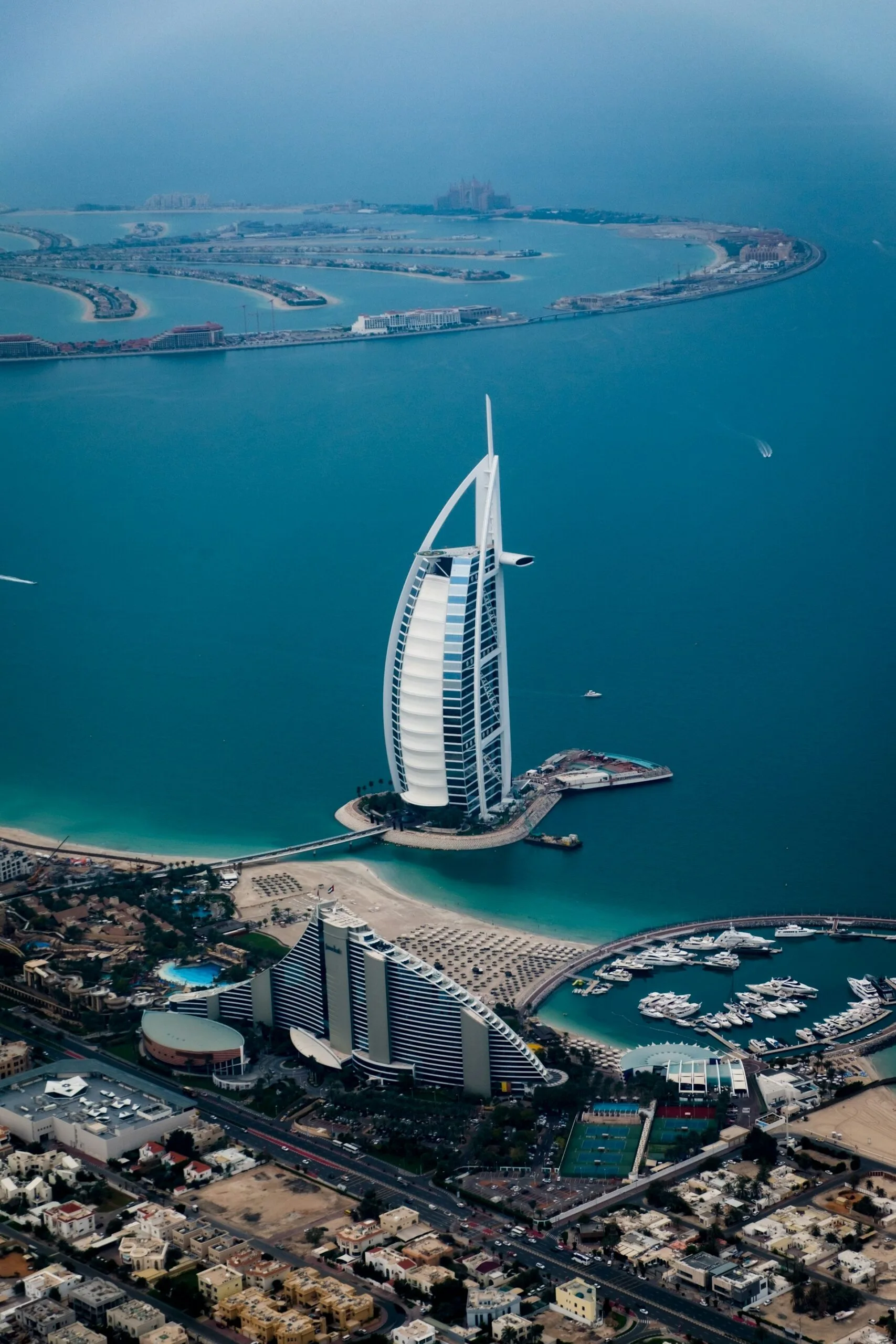 The Burj Al Arab, one of the world's tallest hotels, viewed from above on it's island in the deep blue water.