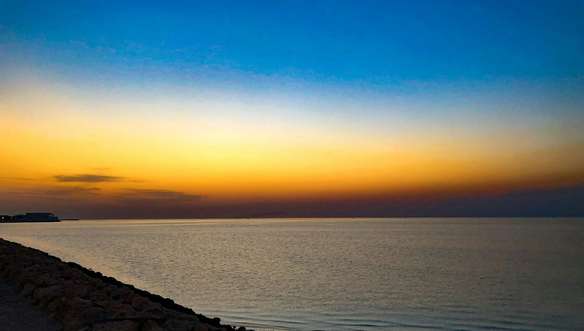 Multicolored sunset over rippling water in Bahrain.